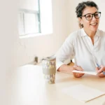 Zwei Frauen im Gespräch bei einer Beratungssituation am Tisch.